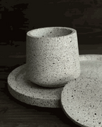 Offene helle Betondose aus Beton auf ovalem Tablett mit losem Deckel