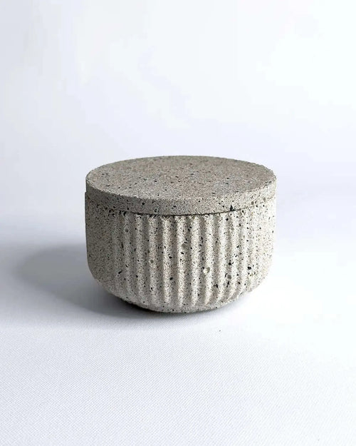 Geriffelte Betonschale mit passendem Deckel in heller Steinoptik.