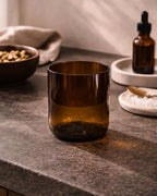 Braunes Glas als minimalistisches Wohnaccessoire auf Steinoberfläche.