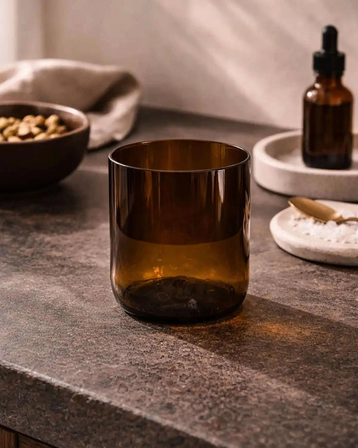 Braunes Glas als minimalistisches Wohnaccessoire auf Steinoberfläche.