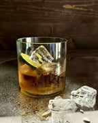 Klares Altglas mit Drink, Eiswürfeln und Limette als Cocktailglas