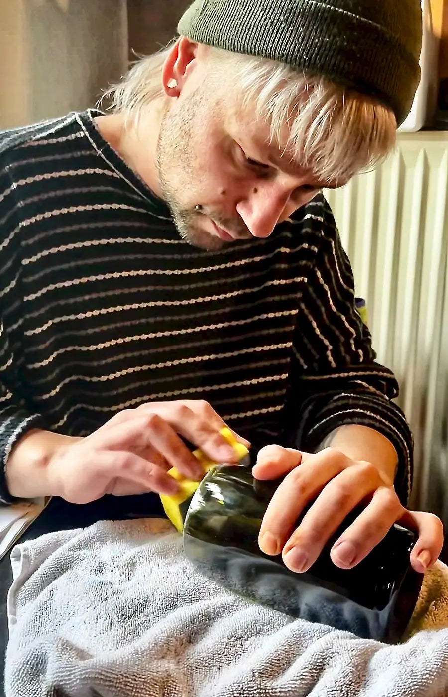 Geschnittene Weinflasche wird per Hand geschliffen.