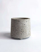 Weißer, zylindrischer Beton-Übertopf Little Potvin mit rauer Oberflächenstruktur.