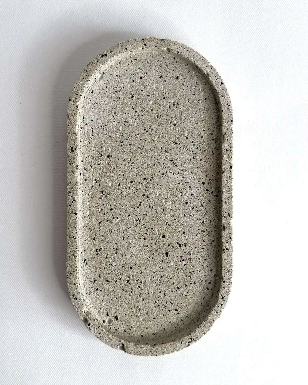 Kleiner, hellgrauer Dekoteller Petovel aus massivem Beton als Produktfreisteller.
