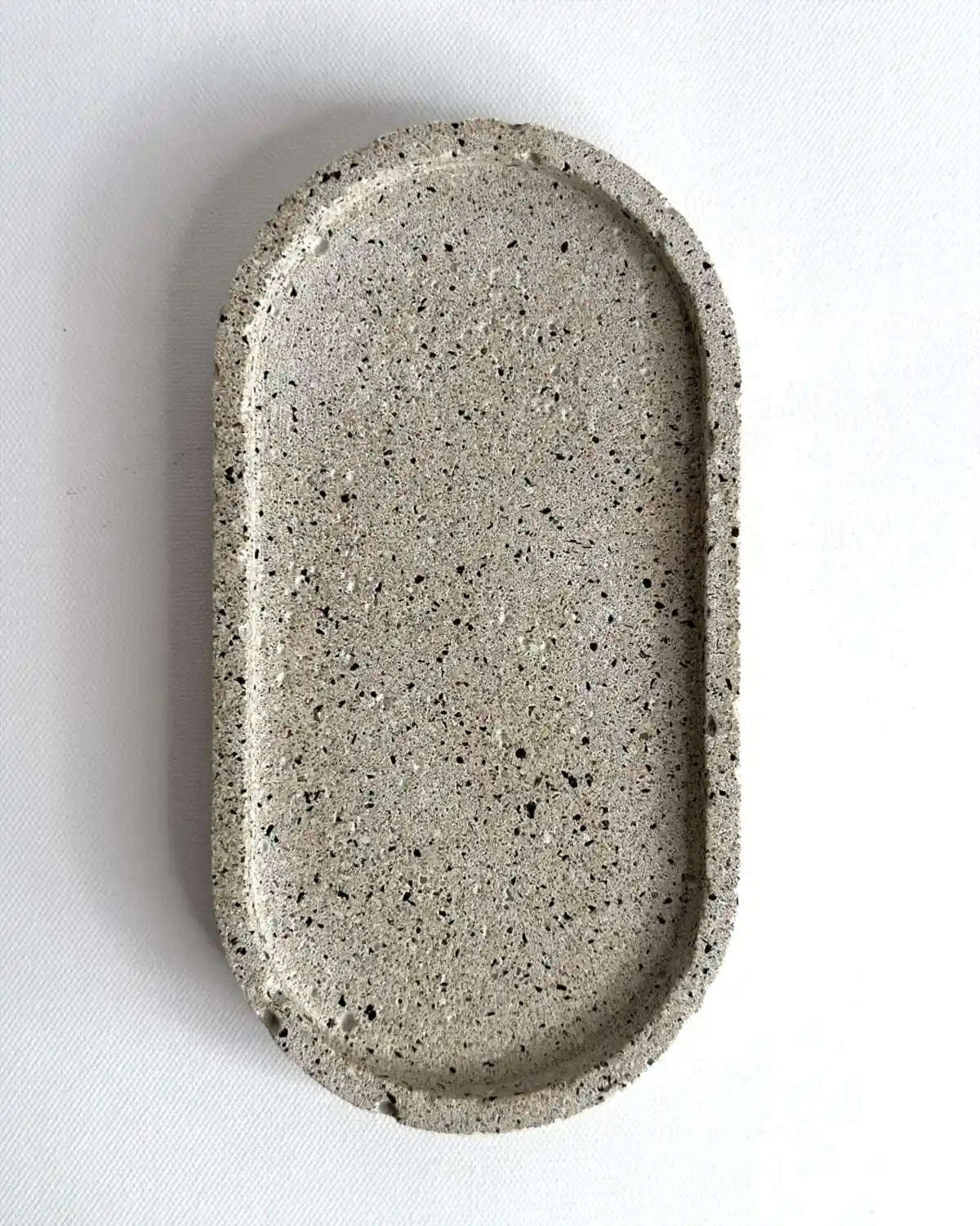 Kleiner, hellgrauer Dekoteller Petovel aus massivem Beton als Produktfreisteller.