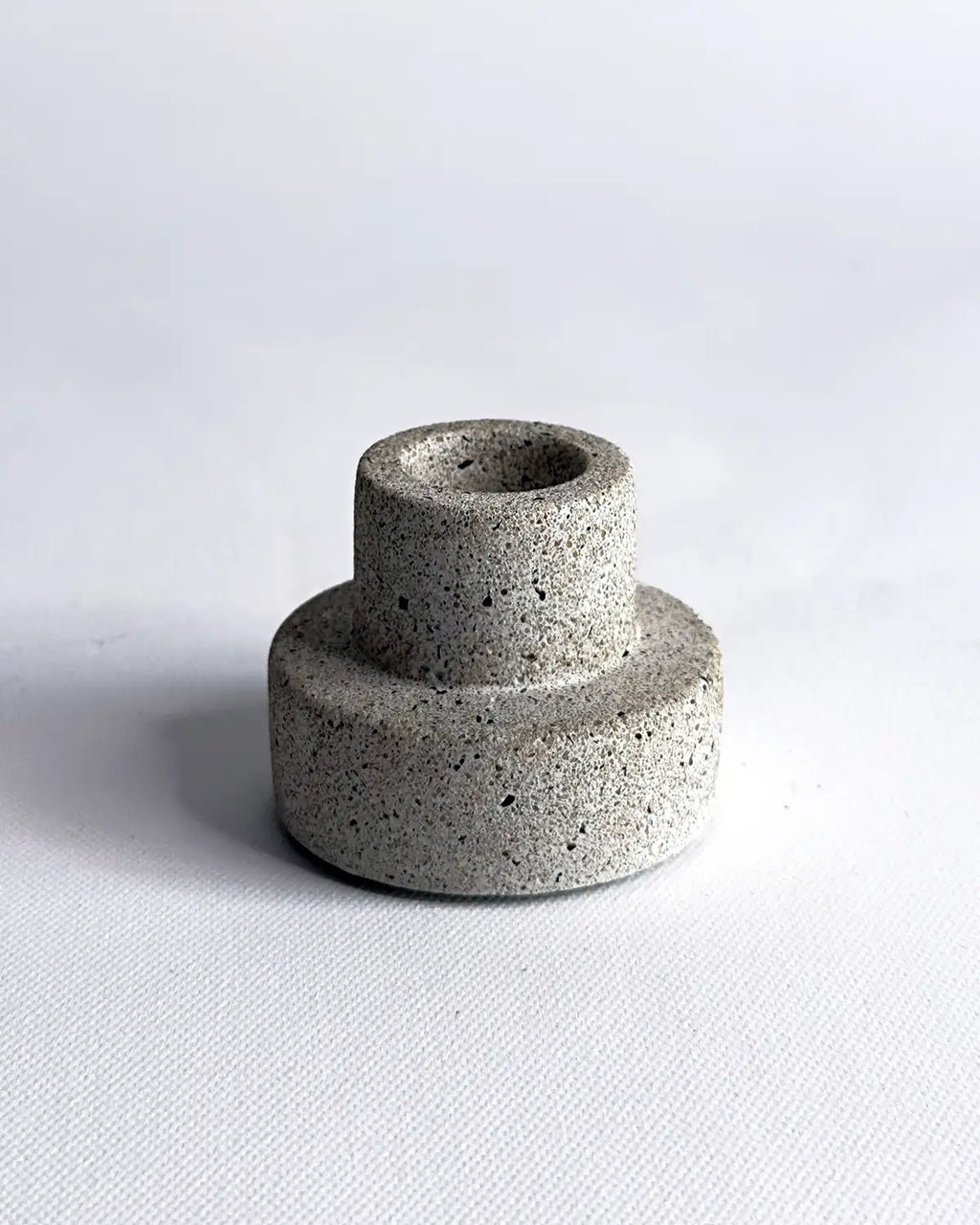 Beige kleiner Kerzenhater aus Beton auf hellen Untergrund.