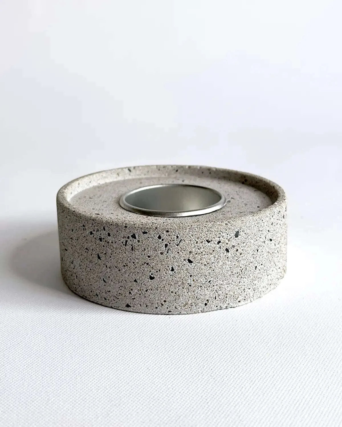 Beton-Teelichthalter mit Metalleinsatz vor hellem Hintergrund