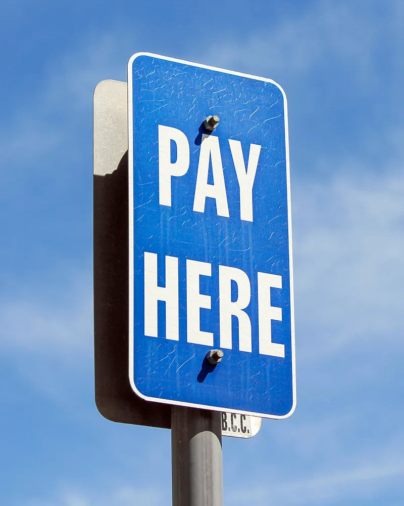 Pay-Here-Schild im Außenbereich als Hinweis auf Bezahlung, Checkout und Kaufabschluss im Shop